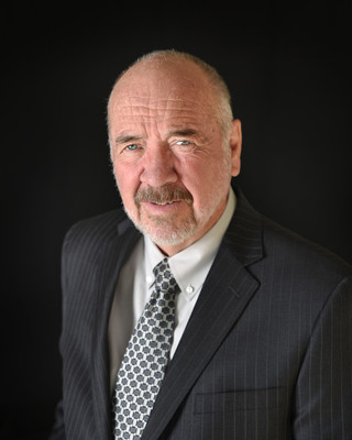 formal headshot of an executive with black background