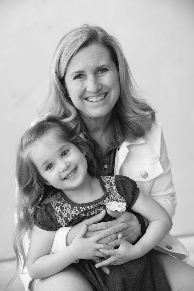 Grandma and 3 year old Grand daughter hug and smile at the camera. photo is in black and white